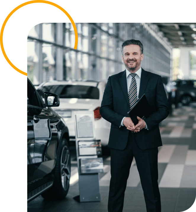 A man in a suit stands confidently in front of a luxury car, showcasing a professional and polished appearance
