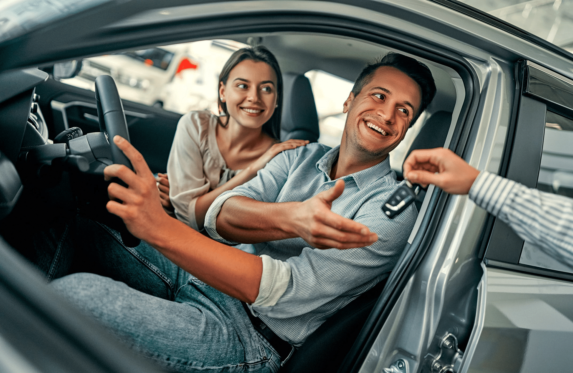 Man and woman sitting in a car discussing car buying tips.